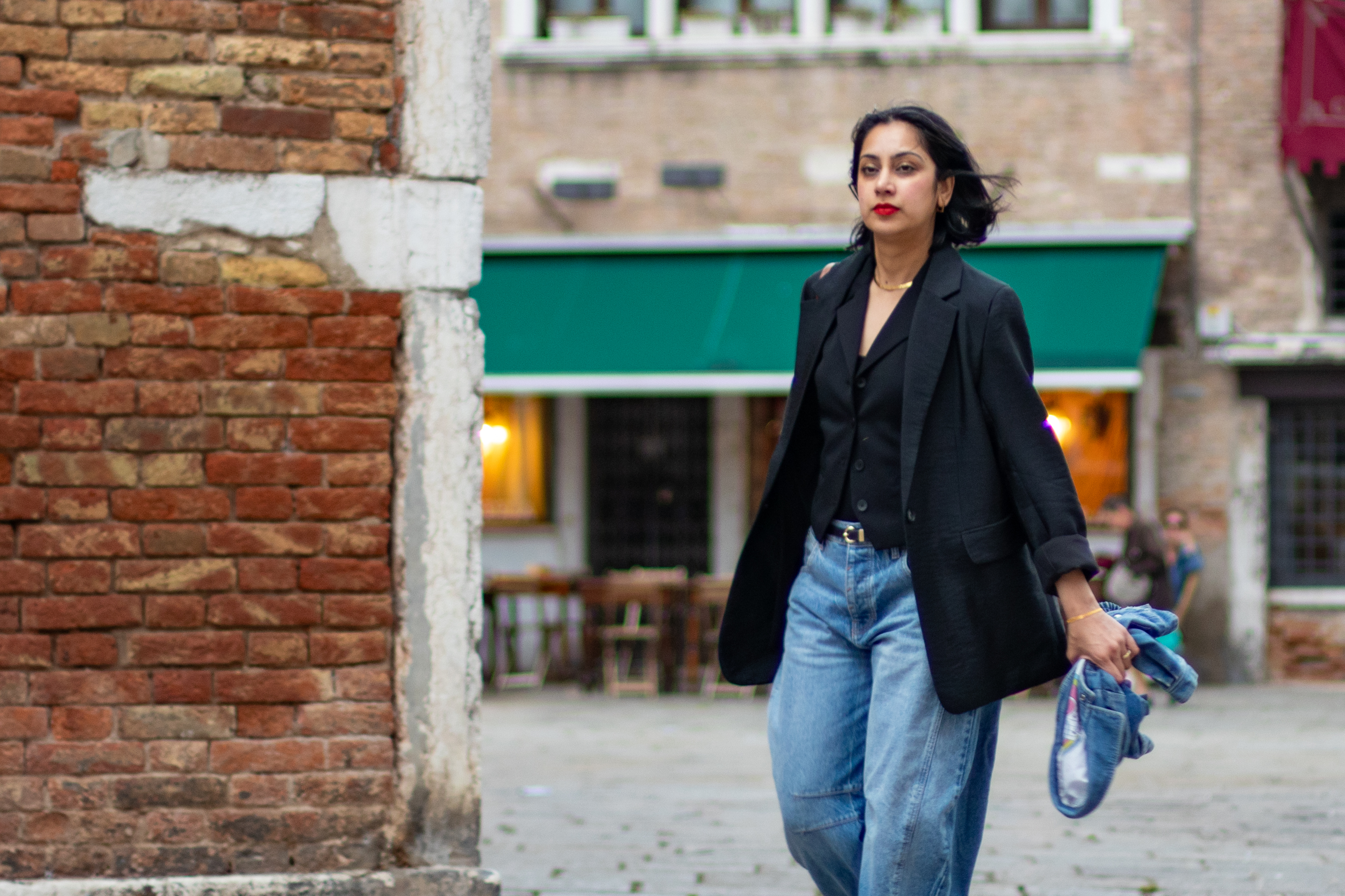 Mujer caminando con una chaqueta por una calle de Venecia