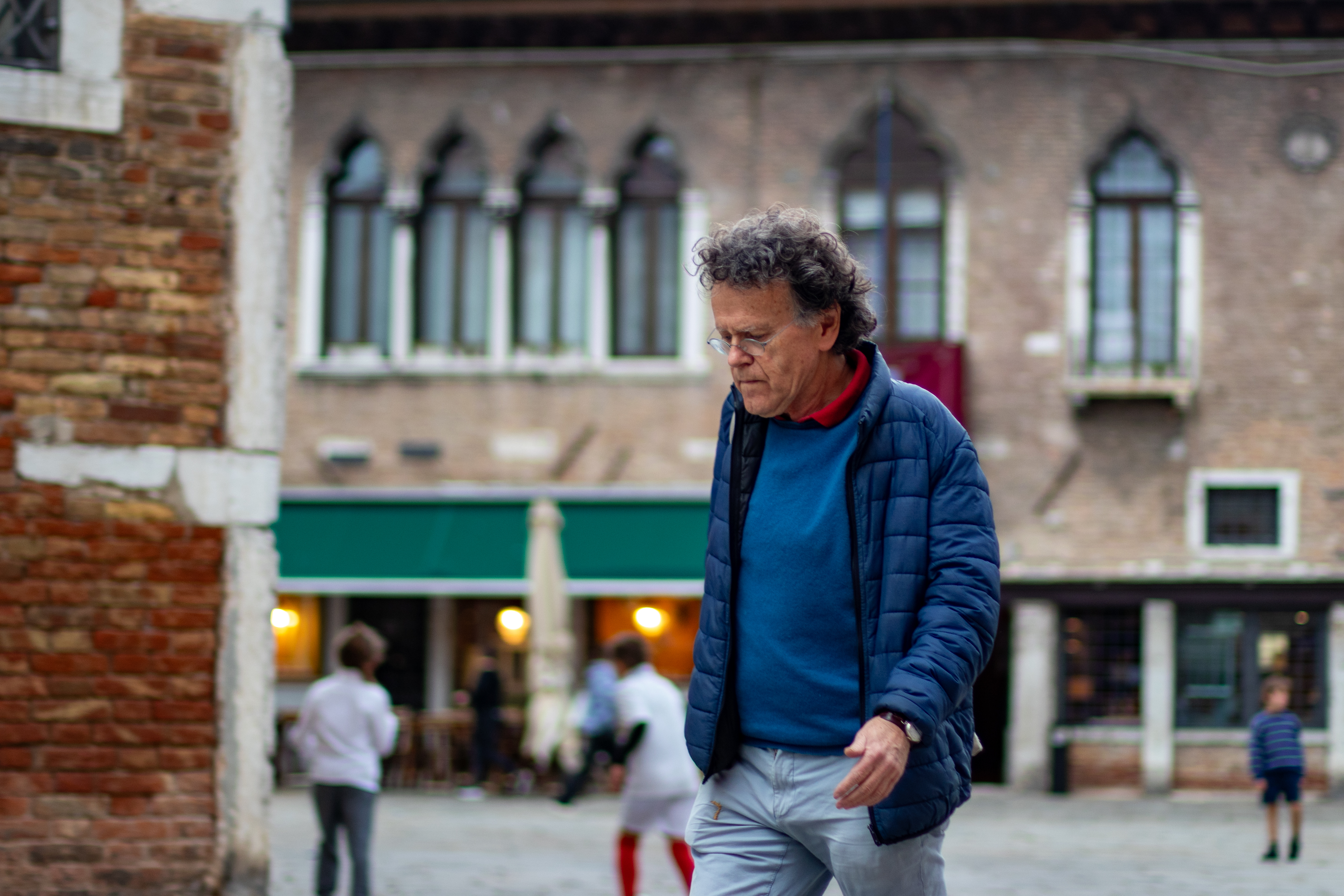 Hombre caminando solo por una calle veneciana camino a una reunión