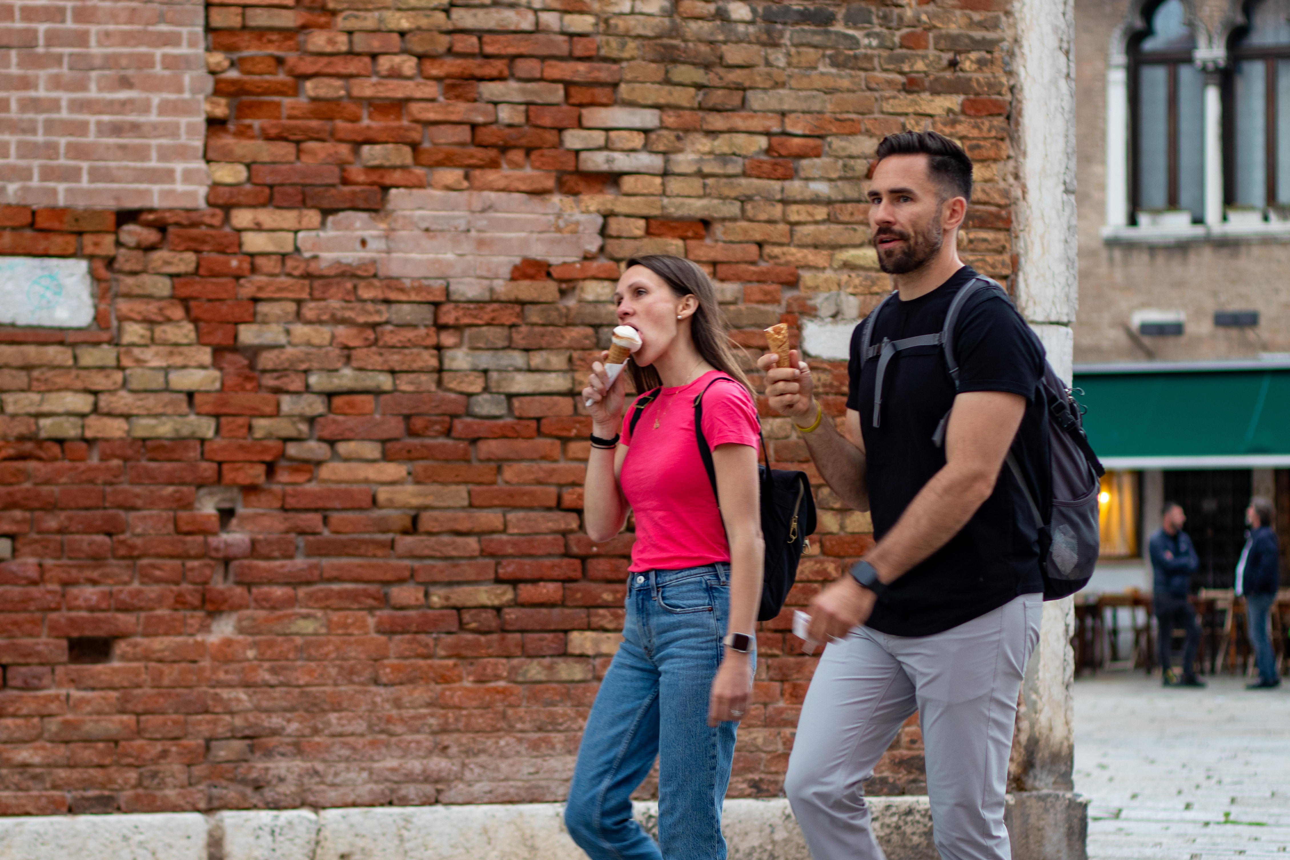 Pareja caminando con helados en silencio por Venecia